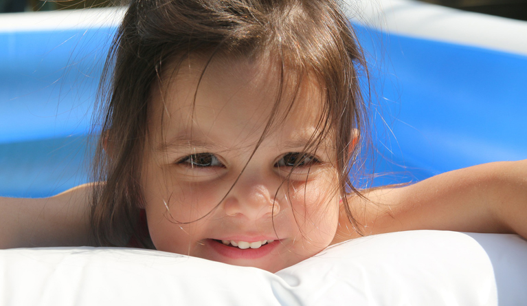 Toddler playing in a paddling pool